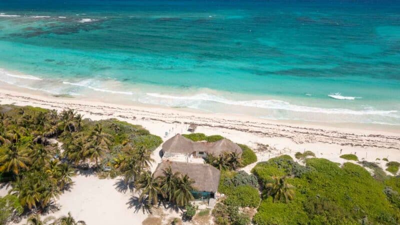 Aerial photo of Xcacel Beach, showing its stunning clear-waters, white sand and the flora and fauna.