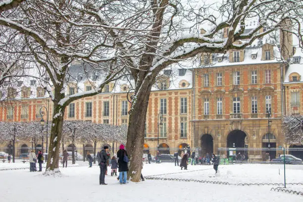 During winter, La Place des Vosges exudes a quiet, timeless charm. Its elegant red-brick arcades and perfectly symmetrical architecture are dusted with snow, creating a postcard-perfect Parisian scene.