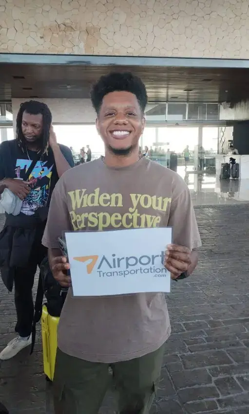 Cliente feliz recibido por el equipo de Airport Transportation en el aeropuerto. ¡Reserva tu transporte privado hoy!